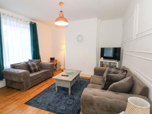 a living room with two couches and a tv at Ash House in Altrincham