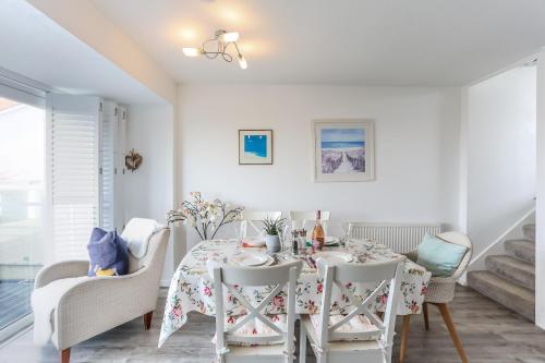 a white dining room with a table and chairs at Sea View 3 bedroom seaside property in Chichester