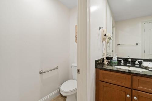 a white bathroom with a toilet and a sink at Indigo East 1003 in Perdido Key