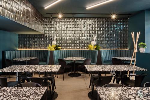 a restaurant with tables and chairs in a room with blue walls at JO&JOE ROMA in Rome