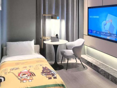 a room with a bed and a table and a tv at Novotel Shanghai Caohejing in Shanghai