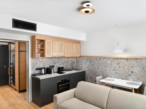 a living room with a couch and a kitchen at Mercure Debrecen in Debrecen