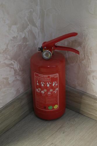a red fire hydrant sitting in the corner of a room at Hotel Louis in Mestia
