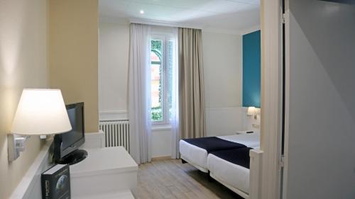 a hotel room with a bed and a window at 1881 Hotel Balneario Vichy Catalan in Caldes de Malavella