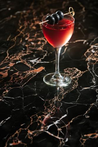 a drink in a glass with black olives on a table at Sofitel New York in New York
