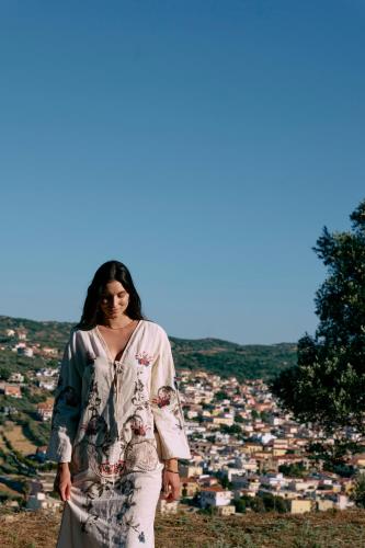 a woman standing on a hill in front of a city at Arcasa Villas Collection by Omilos Hotels in Archanes