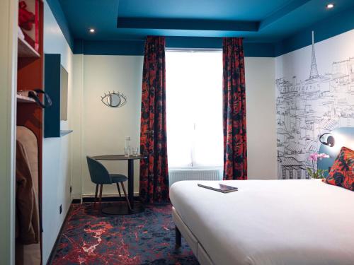 a hotel room with a bed and a table at Ibis Styles Paris Batignolles in Paris