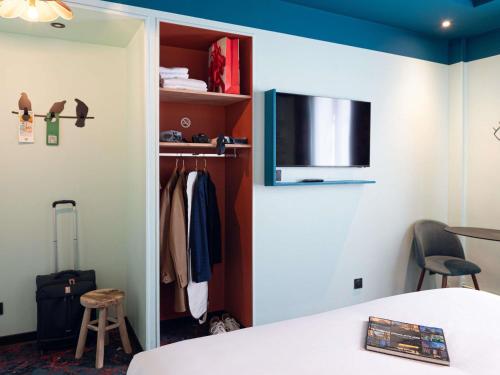a room with a closet with a tv on the wall at Ibis Styles Paris Batignolles in Paris