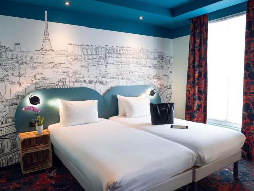a bedroom with a large bed and a wall with a mural at Ibis Styles Paris Batignolles in Paris