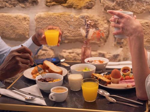 a group of people sitting at a table with food at Ibis Styles Paris Batignolles in Paris