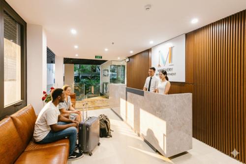 a group of people sitting in a lobby with luggage at Margaery Boutique Apartment & Skyon9 Rooftop Bar in Hanoi