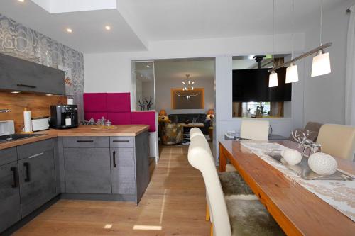a kitchen with a long counter and a table at Upland-Flair Ferienwohnung WALDPFAD im Zentrum! in Willingen