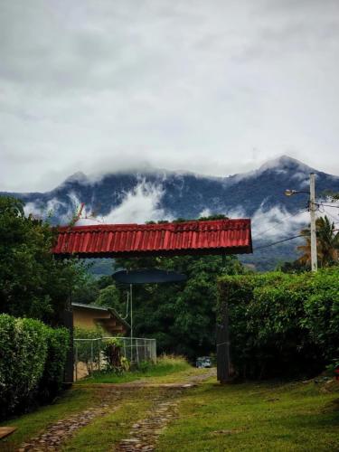 a red bridge with a mountain in the background at La Qhia Eco Retreat in Santa Fe