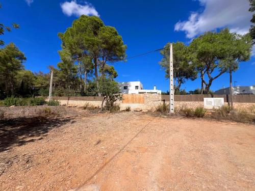un chemin de terre devant une clôture et des arbres dans l'établissement Spacious & Luxury villa in Ibiza - Santa Gertrudis - Villa Chiquita, à Santa Gertrudis de Fruitera