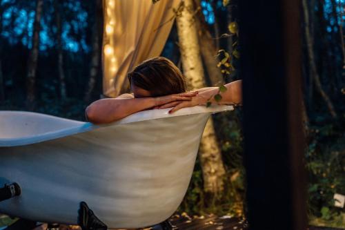 a woman is sitting in a bath tub at Czas na Las in Żarnowska