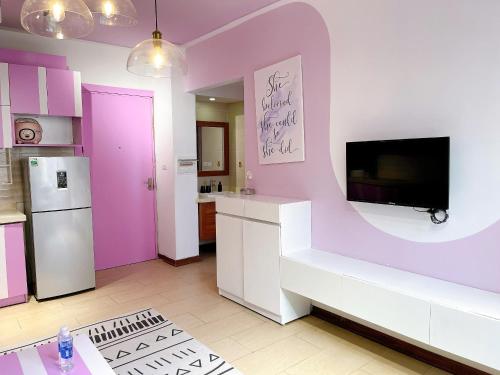 a kitchen with purple walls and a tv on a wall at Tu Hoa Hotel by Luxe Hospitality in Hanoi
