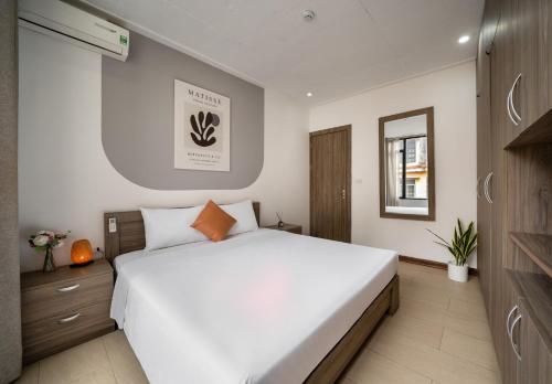 a bedroom with a large white bed and a mirror at Tu Hoa Hotel by Luxe Hospitality in Hanoi