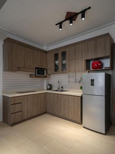 a kitchen with wooden cabinets and a white refrigerator at Tu Hoa Hotel by Luxe Hospitality in Hanoi