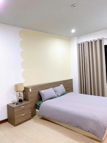 a bedroom with a bed and a night stand with a lamp at Tu Hoa Hotel by Luxe Hospitality in Hanoi