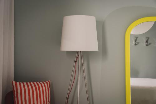 a lamp in the corner of a room with a mirror at Mode Eco Mood Hotel - Adults Friendly in Rimini