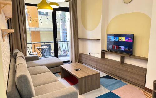 a living room with a couch and a flat screen tv at Tu Hoa Hotel by Luxe Hospitality in Hanoi