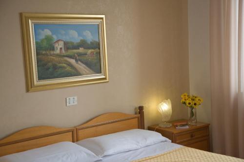 a bedroom with a bed and a painting on the wall at San Gabriele in Loreto