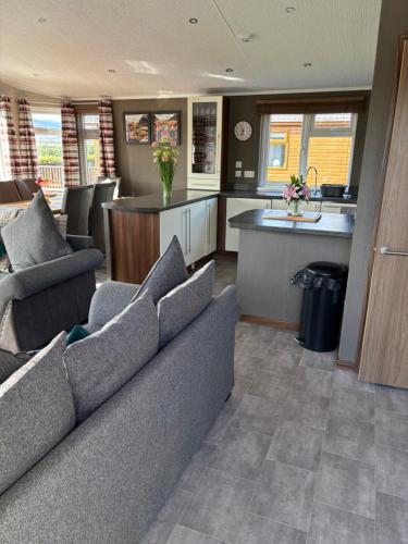 a living room with a couch and a kitchen at Hepburns Lodge 19 in Strachan