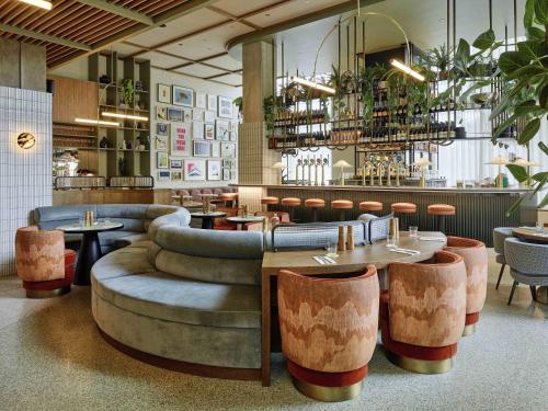 a restaurant with tables and chairs and a bar at TRIBE London Canary Wharf in London