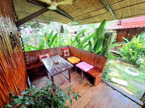 a patio with a wooden bench and a table at Savet Family Homestay & Tour in Battambang