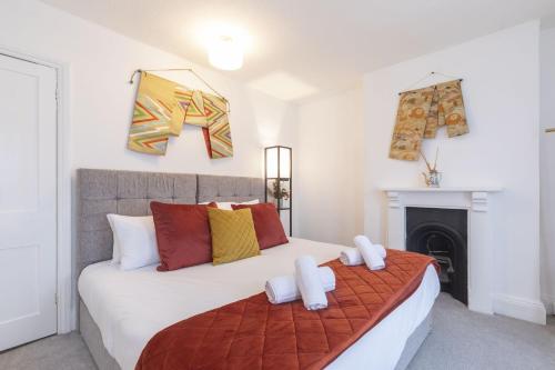 a bedroom with a large white bed and a fireplace at Central 3 Bedroom Home for 7 Guests in Cheltenham