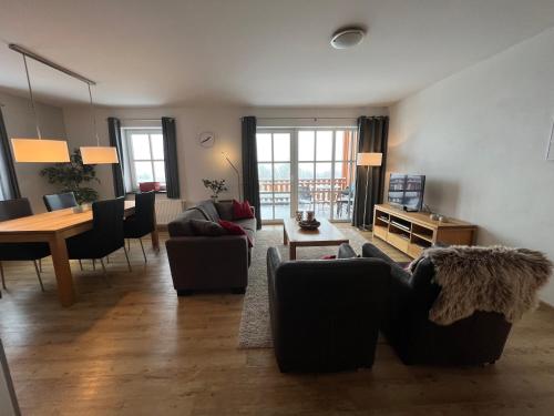 a living room with couches and a dining room at Haus Waldblick in Winterberg