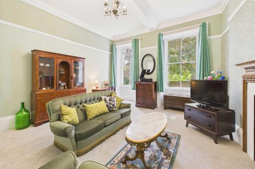a living room with a couch and a tv at Host & Stay - Thorneville House in Knaresborough