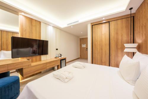 a bedroom with a large white bed and a flat screen tv at Premier Lounge Hotel in Tuzla
