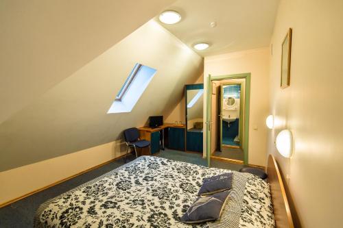 a bedroom with a bed and a desk and a mirror at Palva in Klaipėda