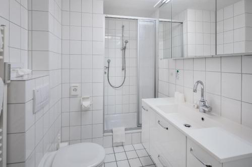 a bathroom with a shower and a toilet and a sink at Appartementhaus Bracht - Kleine Welle in Juist