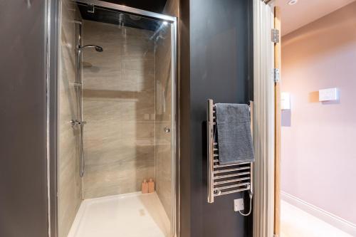 a shower with a glass door in a bathroom at Sleek 1BR City Stay - With Sofa Bed in Central Station