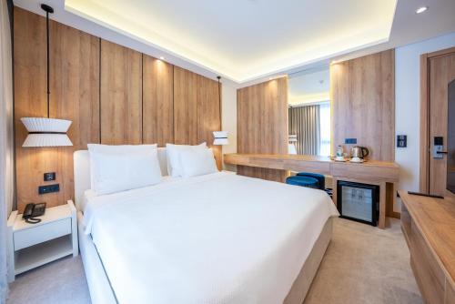 a bedroom with a large white bed and a fireplace at Premier Lounge Hotel in Tuzla