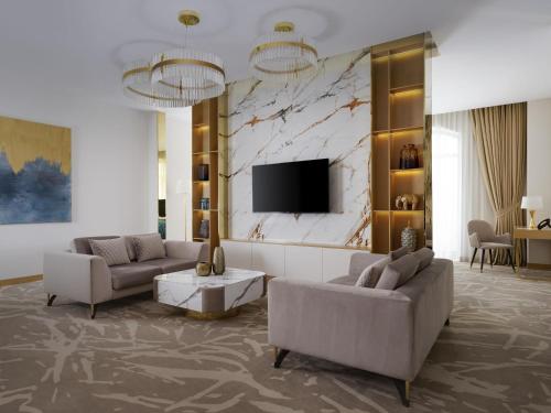 a living room with two couches and a tv at Mercure Tashkent in Tashkent