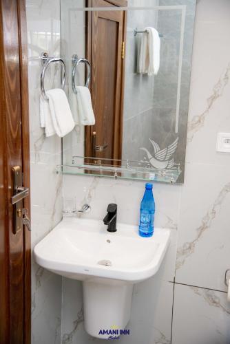 a bathroom with a white sink and a mirror at Amani inn hotel in Kinshasa