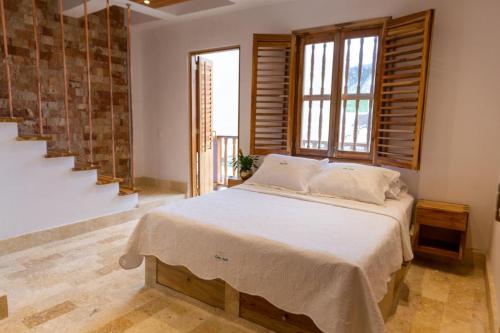 een slaapkamer met een groot bed met een groot raam bij Blue House Castillo View Private Jacuzzi & Colonial Balconies in Cartagena