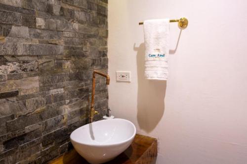 een wit toilet in een badkamer met een bakstenen muur bij Blue House Castillo View Private Jacuzzi & Colonial Balconies in Cartagena