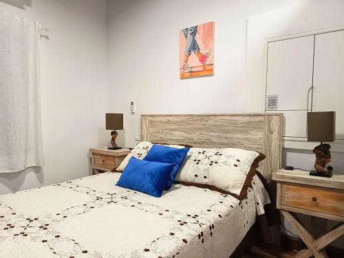 a bedroom with a bed with blue pillows on it at La Casita de Ale Casa Rural cerca Puy du Fou in Polán