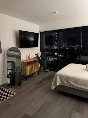 a bedroom with a bed and a view of a city at Original Studio ESCALANTE in San José