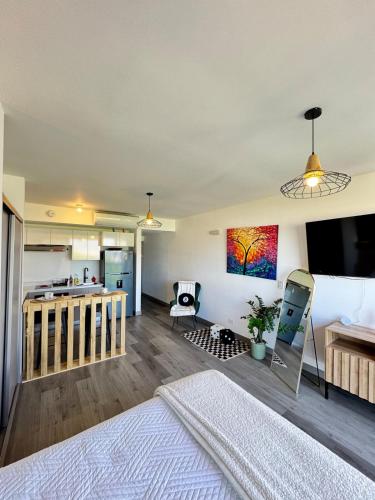 a living room with a bed and a kitchen at Original Studio ESCALANTE in San José