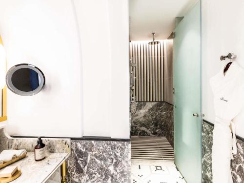 a bathroom with white cabinets and a shower at Fairmont La Marina Rabat Sale Hotel in Rabat