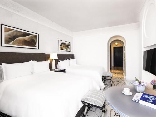 a hotel room with a bed and a table at Fairmont La Marina Rabat Sale Hotel in Rabat