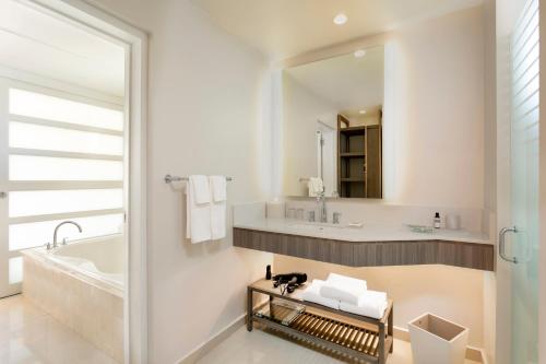 a bathroom with a tub and a sink and a mirror at Hyatt Regency Grand Reserve Puerto Rico in Rio Grande