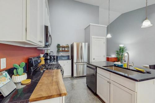 a kitchen with white cabinets and a stainless steel refrigerator at Happy Valley Hideway in Happy Valley