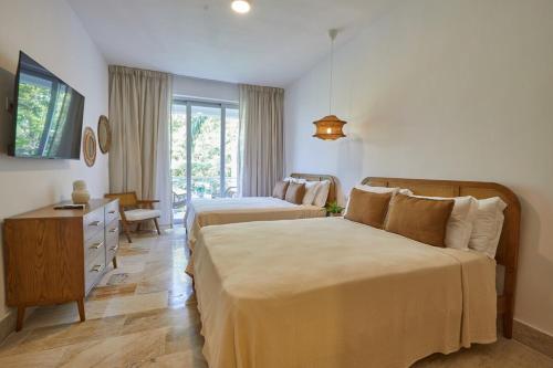 a bedroom with two beds and a dresser and a desk at Modern Escape with Pool & Beach in Puerto Plata