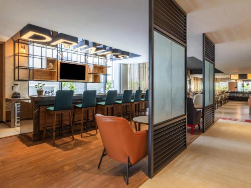 a dining room and kitchen with a long table and chairs at ibis Bengaluru Hebbal - An Accor Brand in Bengaluru